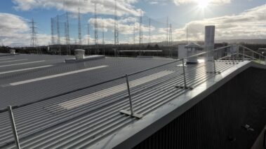 New metal profiled roof reflecting the sky, with visible solar PV system