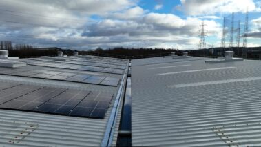 The new metal profiled roof and solar PV system under the glow of the setting sun.