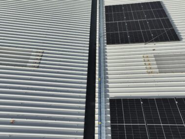 New metal profiled roof and solar PV system gleaming under the sun