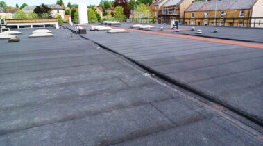 Birds-eye view of the roof showcasing the symmetry and layout of the new roofing system, including all fixtures and installations.