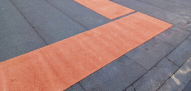 Close-up of the junction where the red demarcated walkway meets the main roof, emphasizing the transition and craftsmanship.