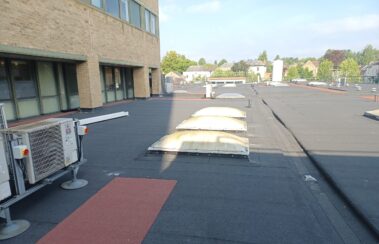 A perspective shot capturing the “Bigfoot” style roof mounts with the air handling units, emphasizing their elevation from the roof surface.