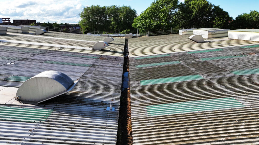 Close-up of an industrial roof in Norwich with ventilation units and a drainage system.