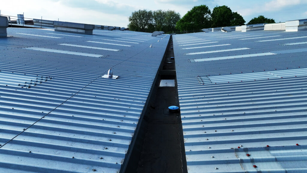 Close-up of modern industrial roof with drainage system and ventilation units in Norwich.