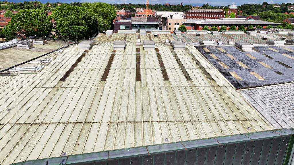 Close-up of an industrial roof in Norwich with ventilation units and a drainage system.