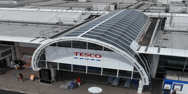 Refurbished glazed atrium and storefront at Tesco Bury with modern glass panels and new signage installed by Weatherproofing Advisors.