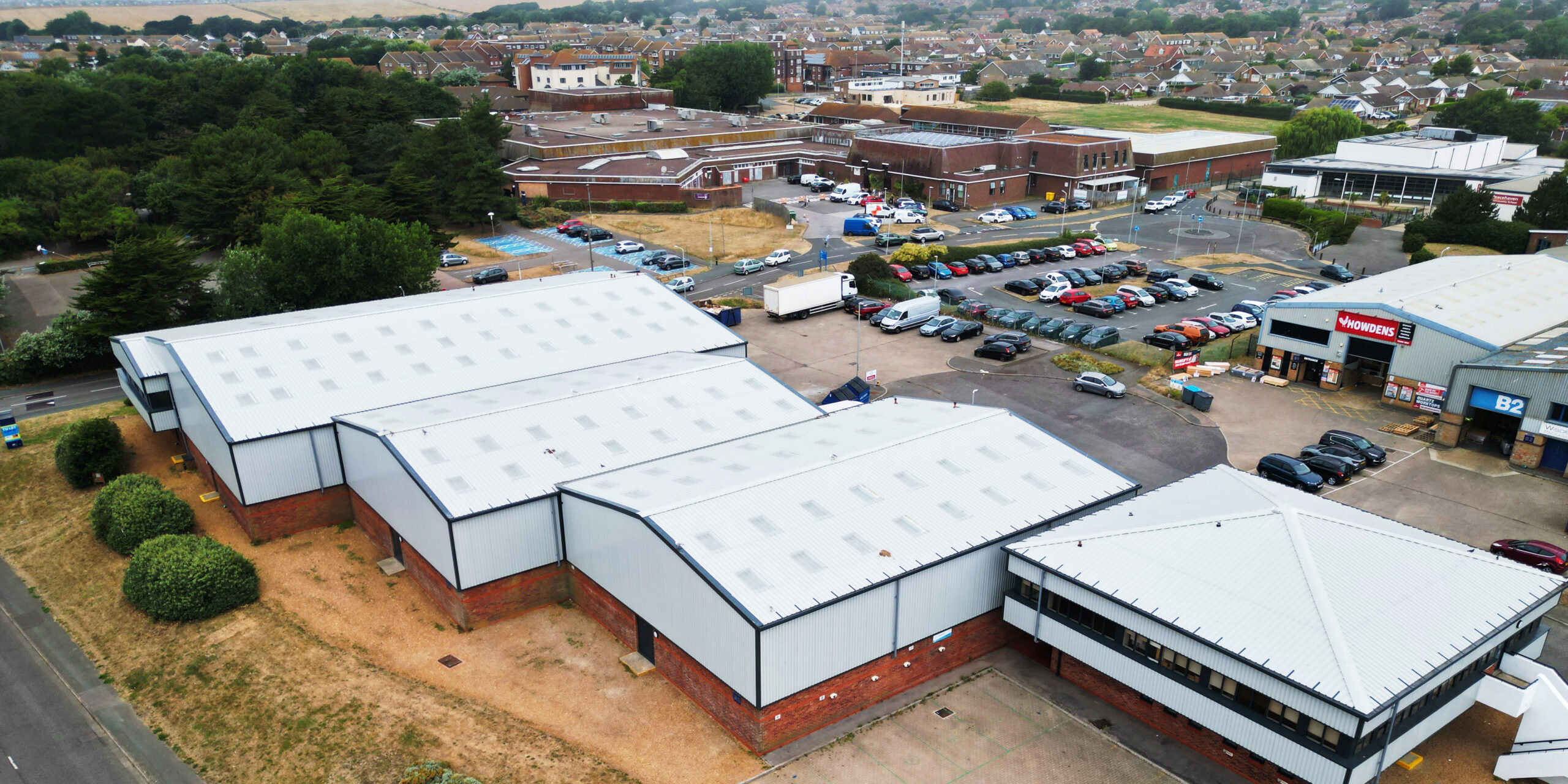 JLL Peacehaven commercial property roof and cladding refurbishment by Weatherproofing Advisors, with new insulation, rooflights, and Anthracite finishes.